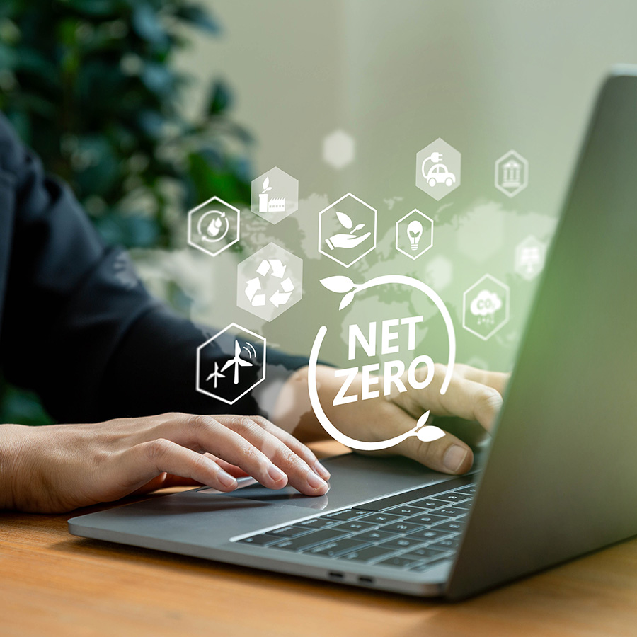 Person, die auf einem Laptop arbeitet, mit Symbolen für Nachhaltigkeit und Klimaschutz rund um das Thema ‚Net Zero‘, das den Fokus auf CO2-Reduktion und umweltfreundliche Technologien verdeutlicht.